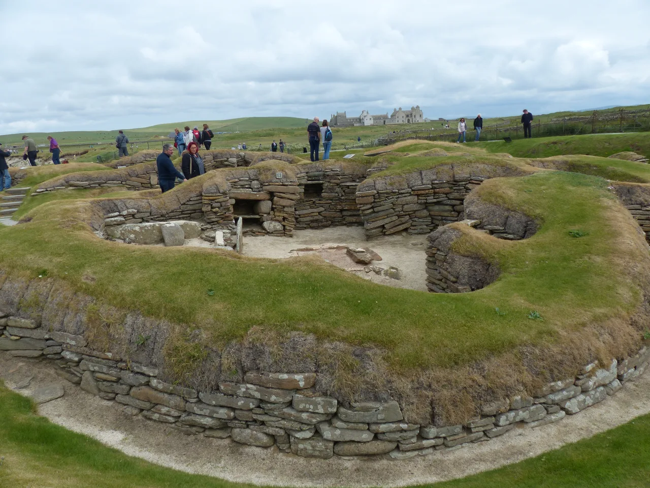 Inside a dry-stone house at Skara Brae, with a stone dresser and bed frames built against the walls