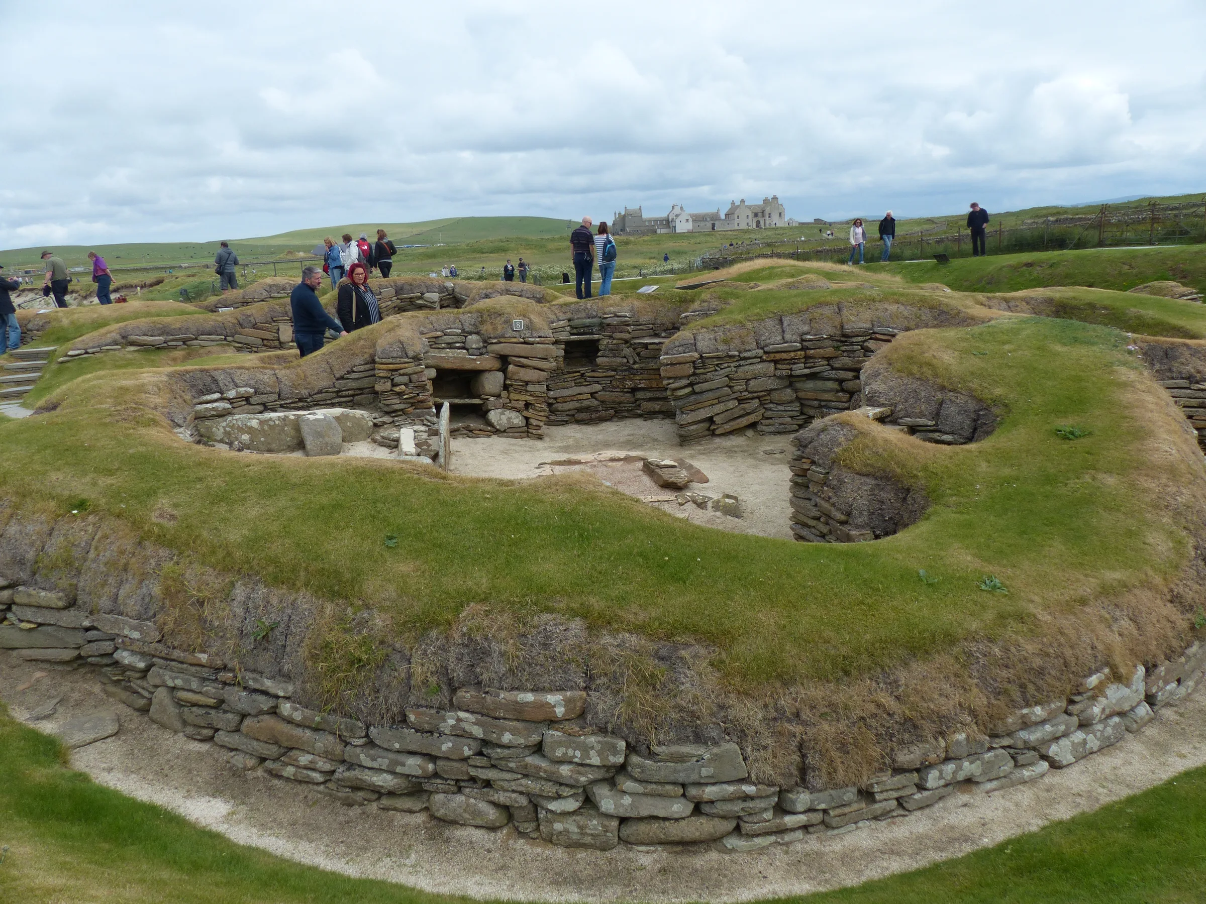 Inside a dry-stone house at Skara Brae, with a stone dresser and bed frames built against the walls