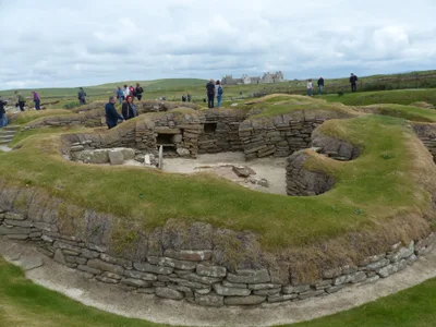 Inside a dry-stone house at Skara Brae, with a stone dresser and bed frames built against the walls