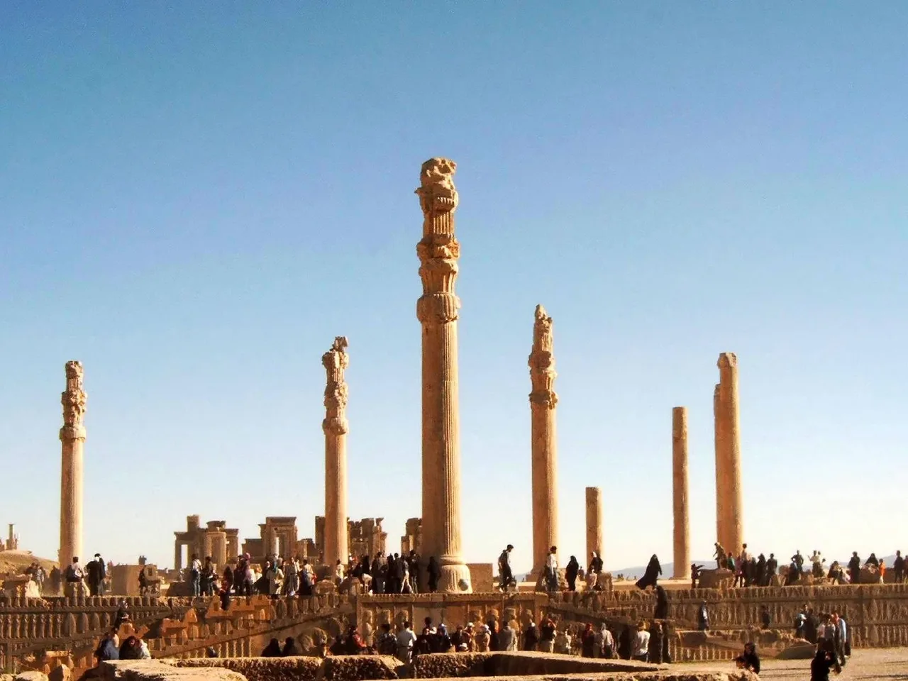 The surviving slender, tall Achaemenid stone columns of Persepolis against the sky