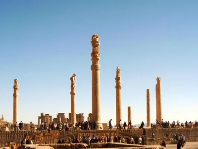 The surviving slender, tall Achaemenid stone columns of Persepolis against the sky