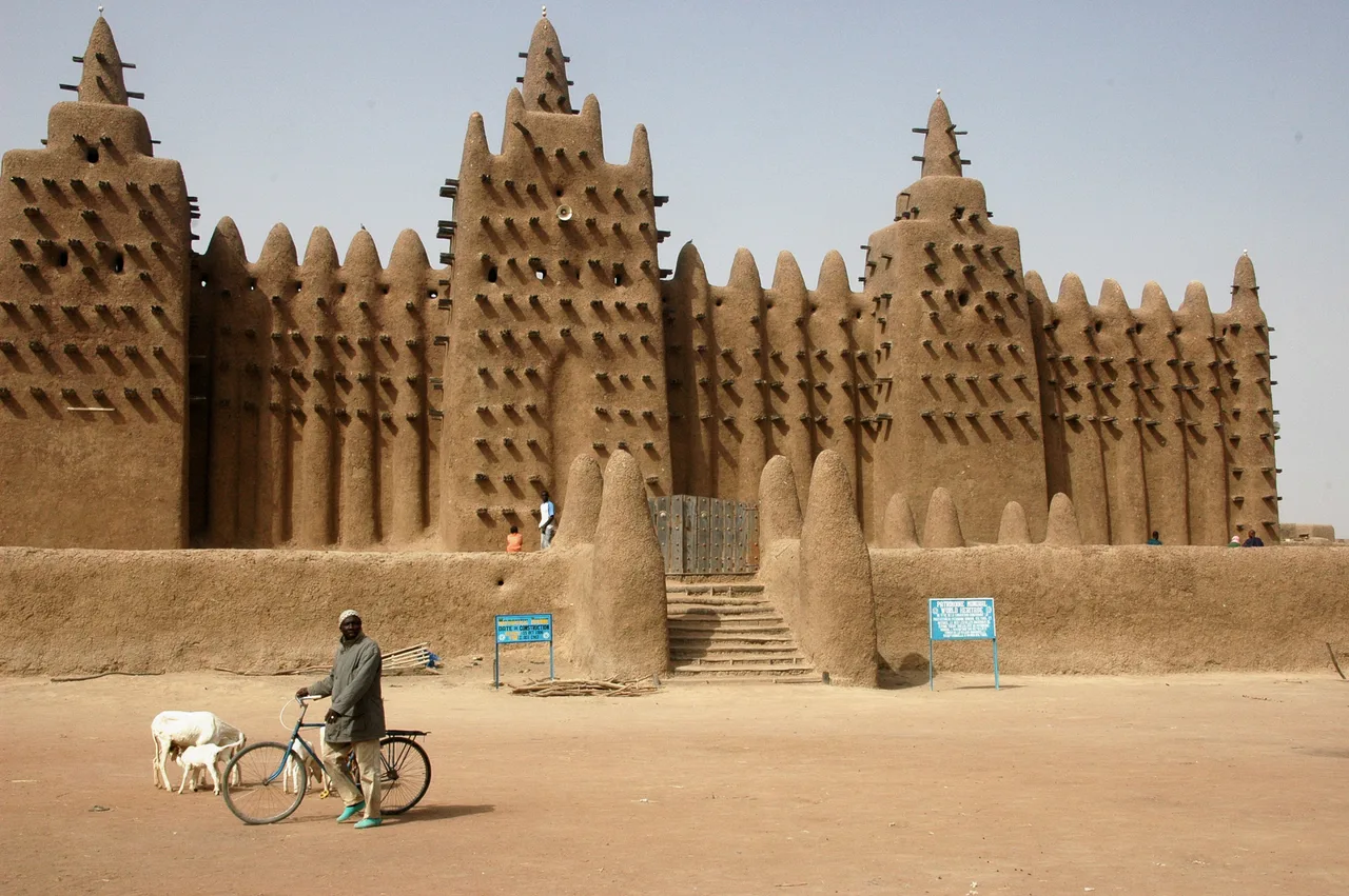 The mud-brick façade of the Great Mosque of Djenné; palm beams (toron) projecting from the walls and conical minarets