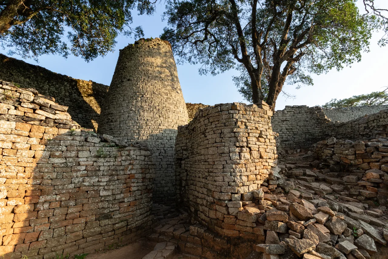 The solid conical stone tower in the Great Enclosure of Great Zimbabwe and the curving mortarless granite wall around it