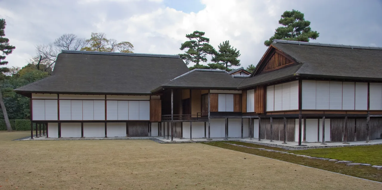 The timber structure of Katsura Villa opening to the garden; sliding screens, the engawa under the eaves, and the pond edge