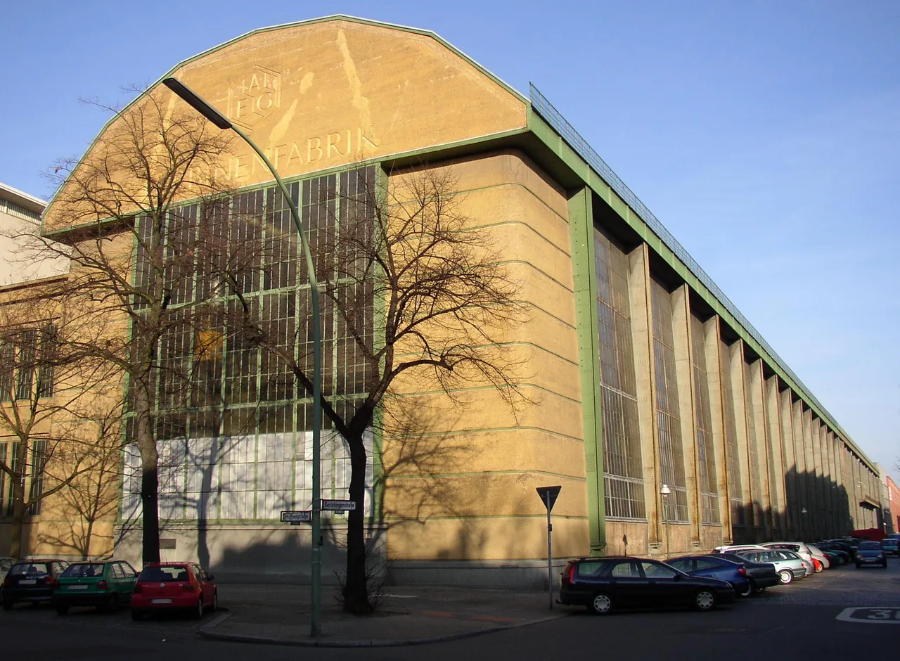 The steel-portal-framed flank of the AEG Turbine Factory, its wide glazing and corner buttresses