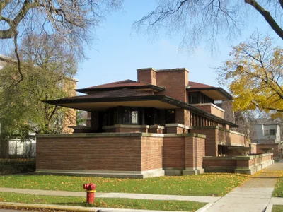 The long horizontal brick masses of Robie House and its columnless cantilevered eaves reaching metres outward
