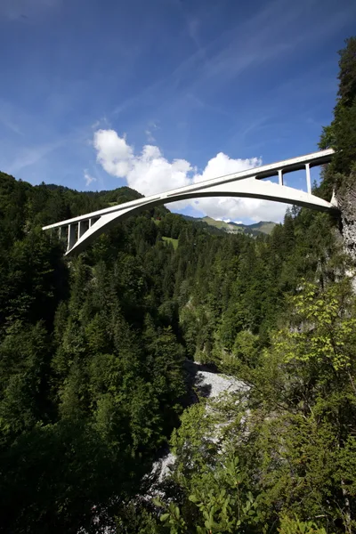 The reinforced-concrete arch of Salginatobel Bridge crossing a deep Alpine valley, slender at the centre and widening at the supports