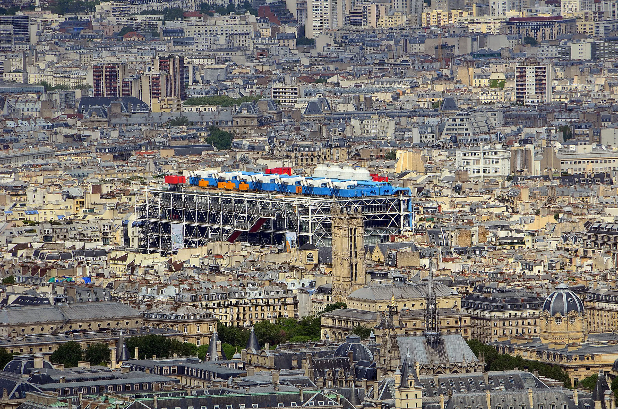Pompidou Merkezi'nin dış cephesindeki çelik strüktür, renkli borular ve cam tüp içindeki yürüyen merdiven