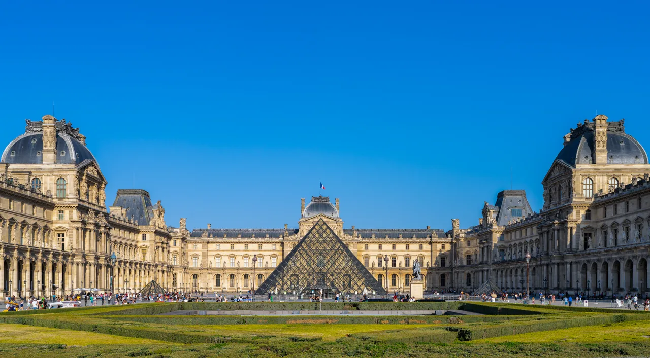 The glass-and-steel pyramid in the Louvre courtyard, with the historic palace facade behind
