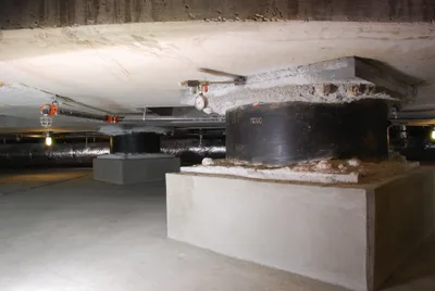 Cylindrical seismic isolators installed between column and foundation in a building's basement