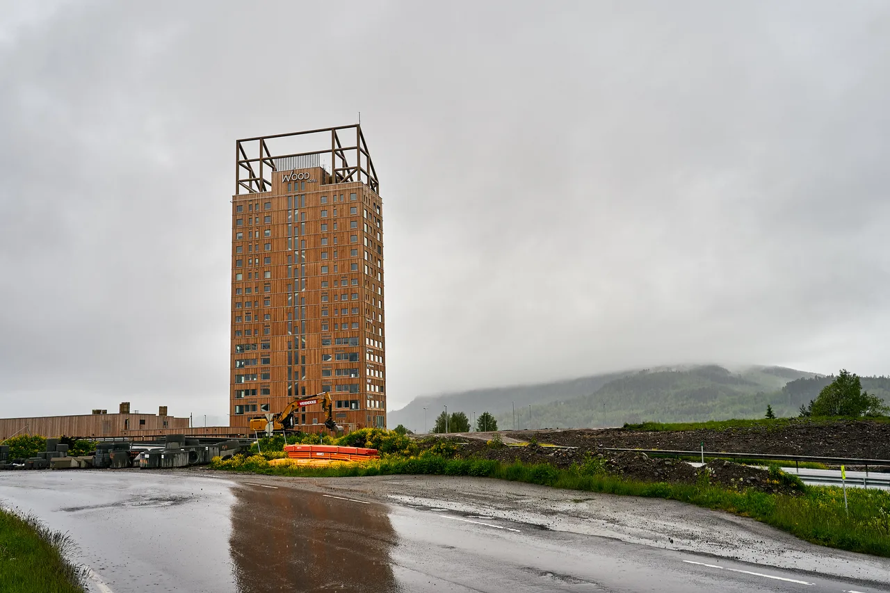 The timber skyscraper Mjøstårnet rising by Lake Mjøsa