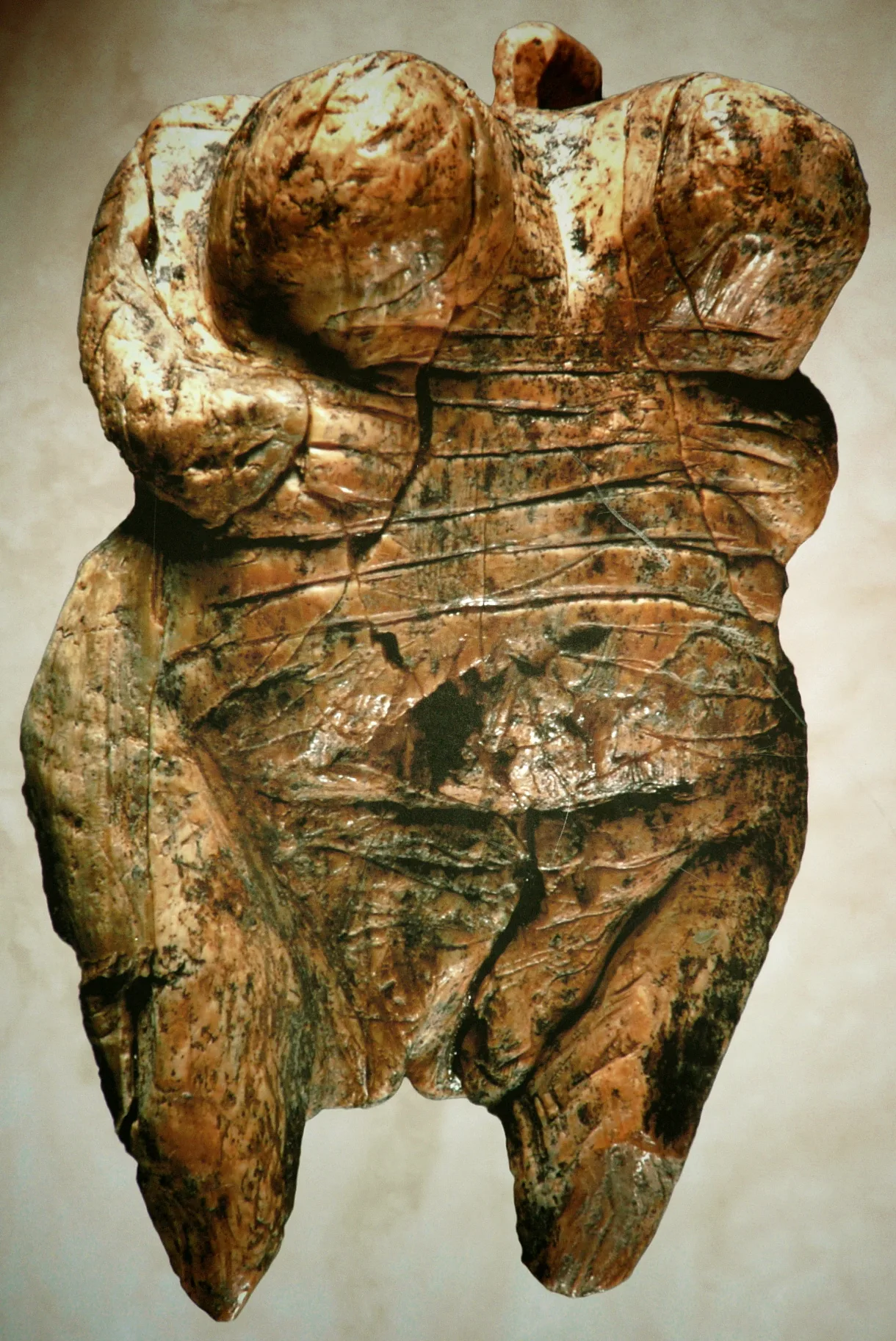 Small headless female figurine with exaggerated body proportions, carved from mammoth ivory