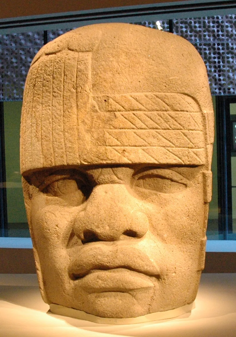 San Lorenzo Monument 4: an Olmec colossal head with full lips, a broad nose, and a tight helmet wrapping the skull