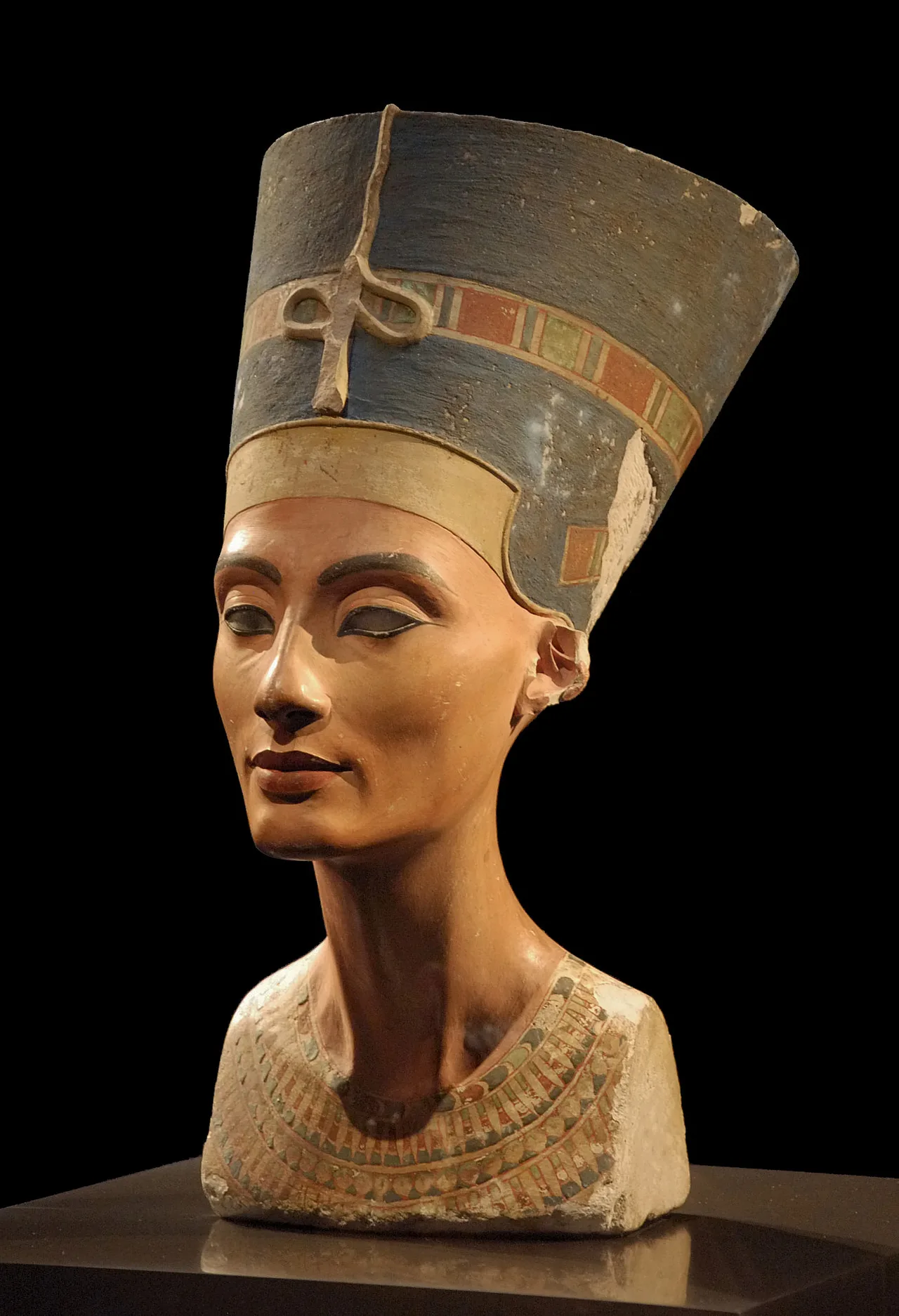 Three-quarter view of the Nefertiti bust: long neck, blue crown, finely traced brows
