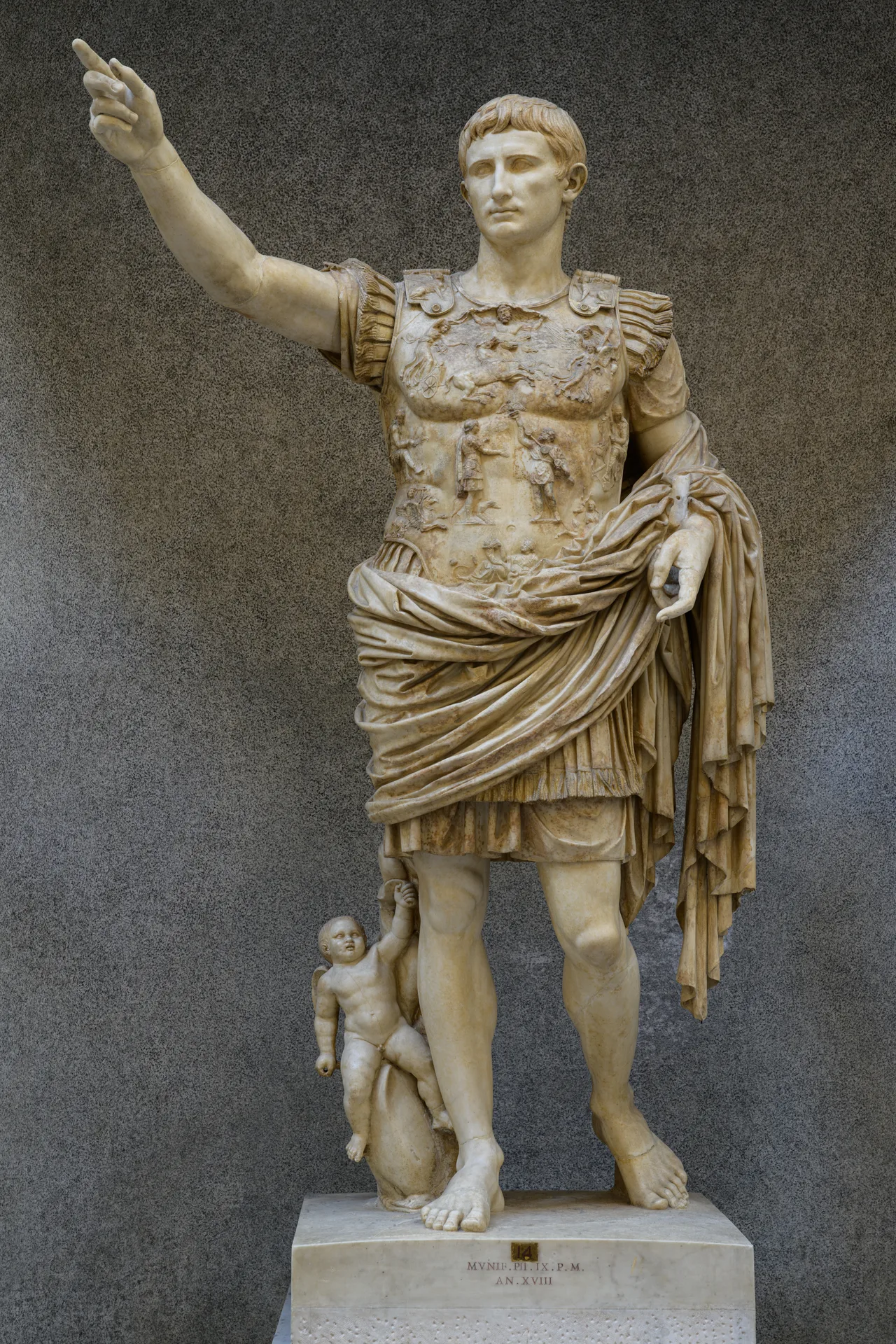 The Augustus of Prima Porta: a full-length marble statue of the emperor in cuirass, right arm raised, a small dolphin-riding Cupid at his foot
