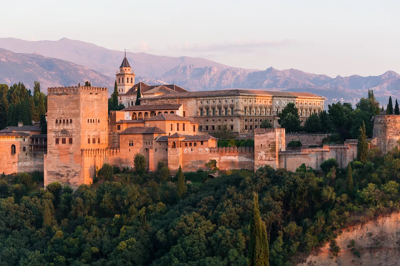 The Alhambra at dawn: massive defensive walls, towers, and the Palace of Charles V