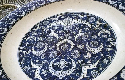 A large Iznik ceramic dish: blue vegetal patterns on a white ground with a wave border at the rim