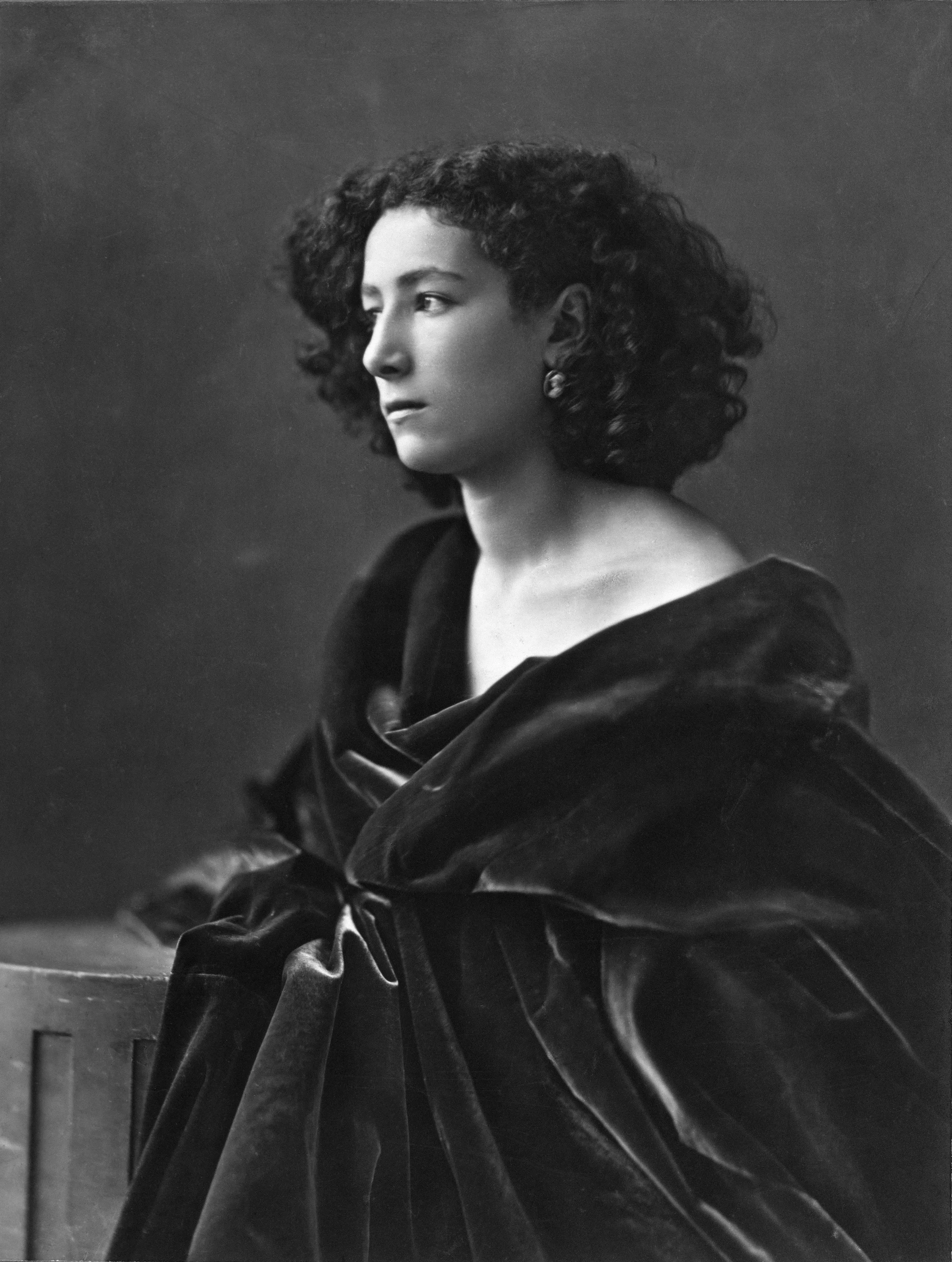 Nadar's 1864 portrait of Sarah Bernhardt: a young woman wrapped in a dark drape, side-lit against a plain ground