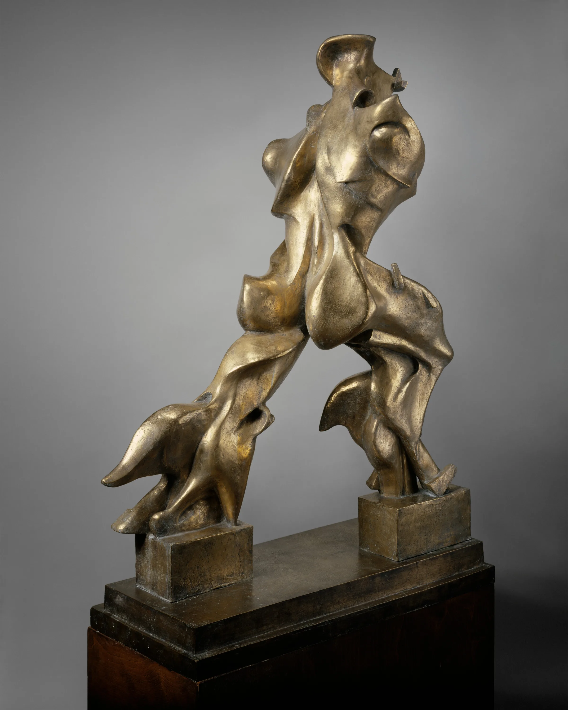 Boccioni's bronze sculpture: a faceless striding figure whose legs and torso extend into masses streaming backwards