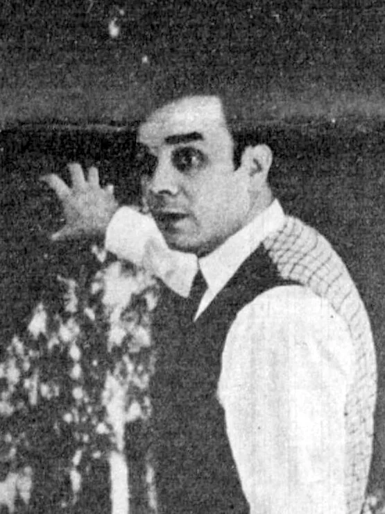 Yves Klein standing in his suit in front of one of his Anthropometry canvases painted in his signature International Klein Blue (IKB)