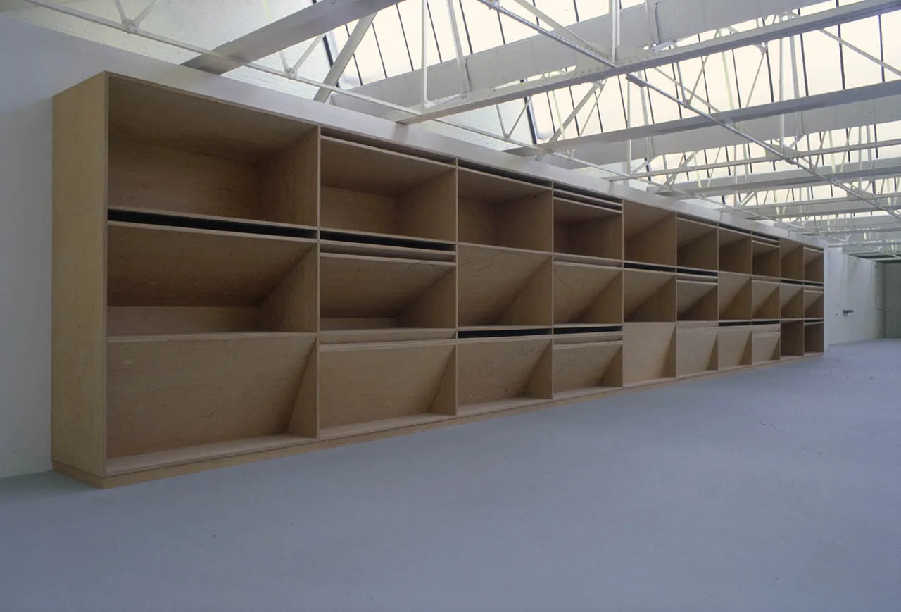 Judd's Untitled (stack): eleven identical galvanised-steel boxes mounted vertically on a white wall, with equal spaces between each