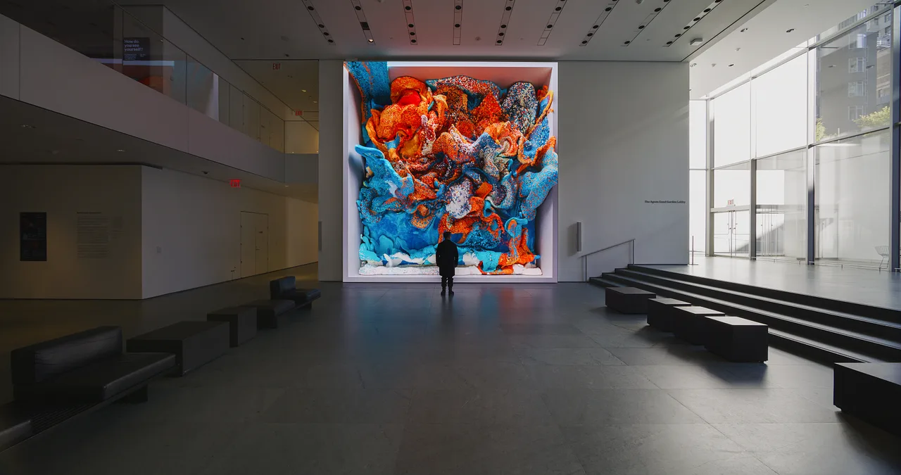 A massive screen in MoMA's lobby displaying flowing, colourful, fluid-like forms generated by an AI model trained on museum archives