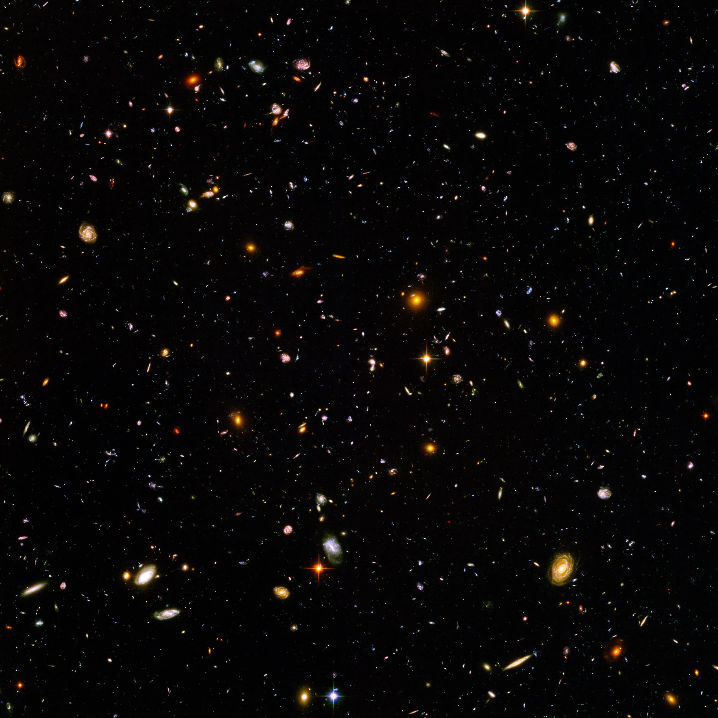 Hubble Ultra Derin Alan görüntüsü — koyu uzayda binlerce küçük galaksi: kıvrımlı, oval, parıltılı, eski morötesinin kırmızıya kaymış görüntüleri