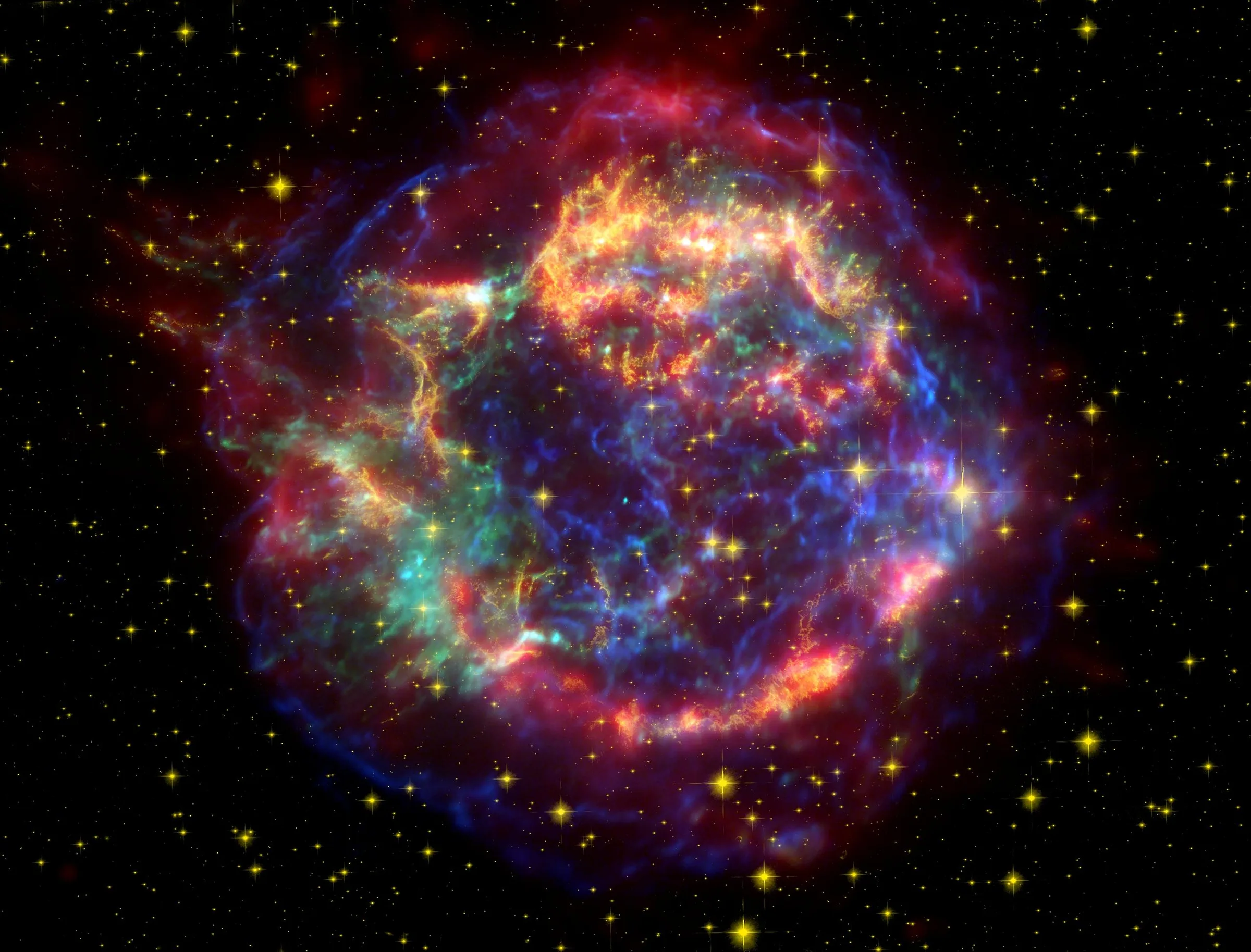 Spitzer Space Telescope infrared image of the Cassiopeia A supernova remnant, with the central neutron star surrounded by ring-shaped debris from the explosion