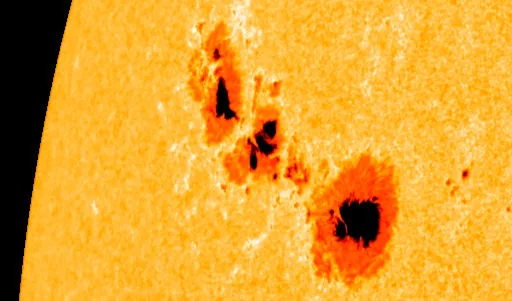 Large, complex dark sunspot groups on the orange surface of the Sun; close-up image from NASA's Solar Dynamics Observatory