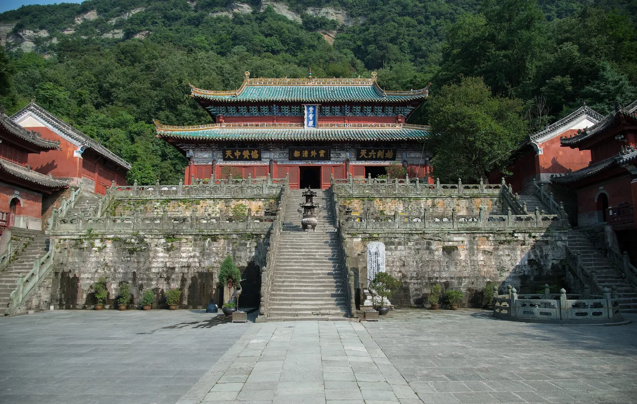 Wudang Dağları'ndaki Zixiao (Mor Bulut) Tapınağı — kırmızı duvarlar, sarı çatılar, sisli zirvelerin arasında
