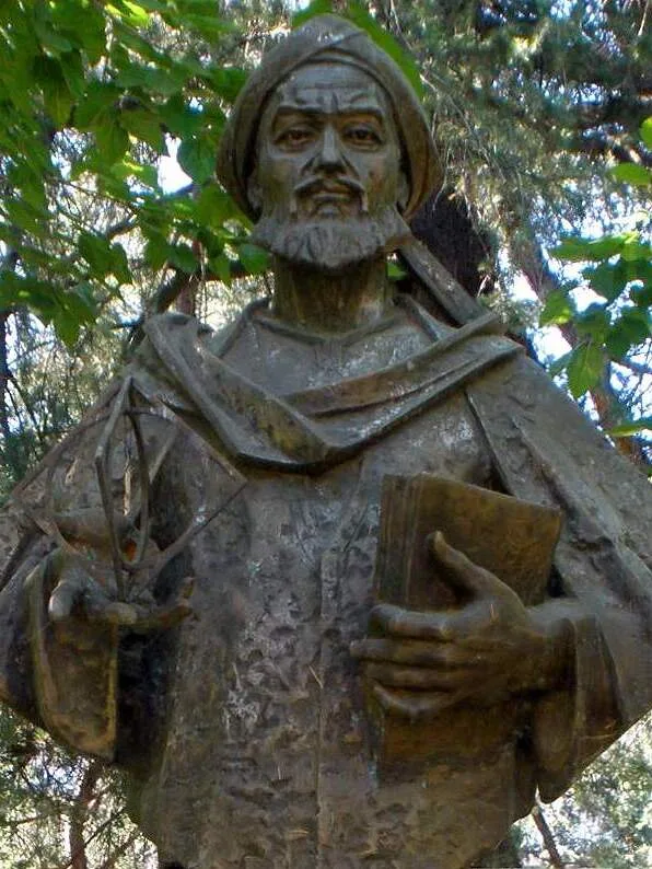 Statue of Muhammad ibn Musa al-Khwarizmi: a robed figure holding a book on a tall pedestal, at Ciudad Universitaria in Madrid