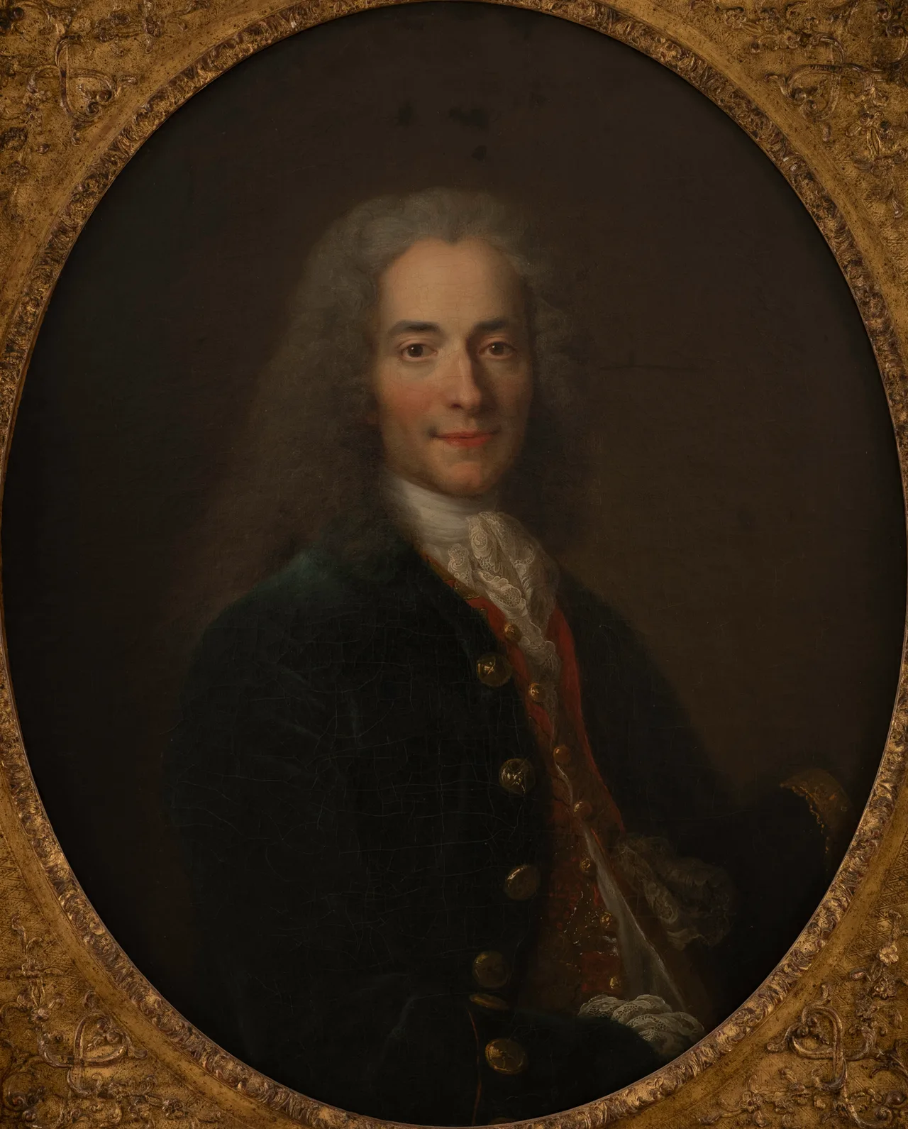 Nicolas de Largillière'in genç Voltaire portresi: uzun bukleli beyaz peruk, mavi-altın işlemeli kaftan, sol elinde tüy kalem