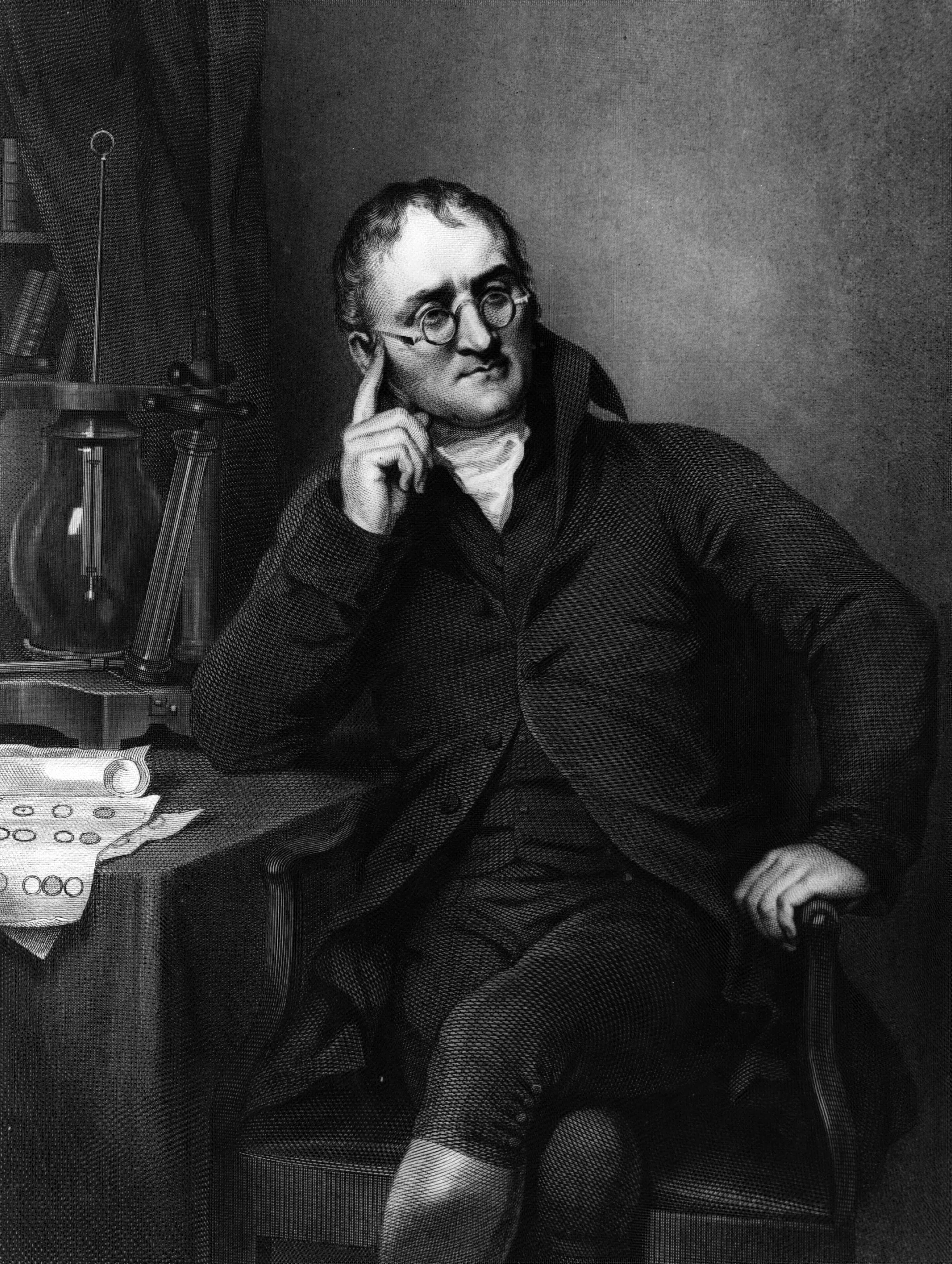 Portrait of John Dalton seated at his desk holding papers