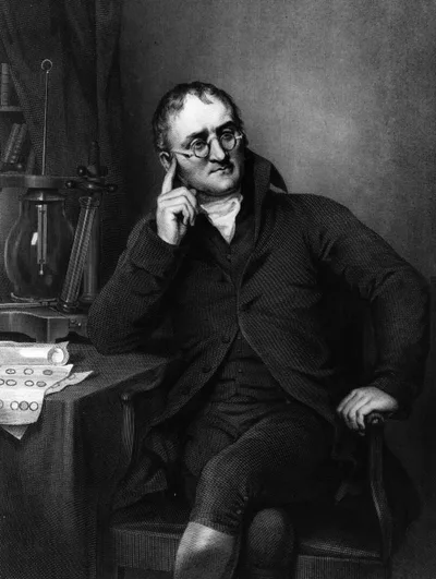 Portrait of John Dalton seated at his desk holding papers
