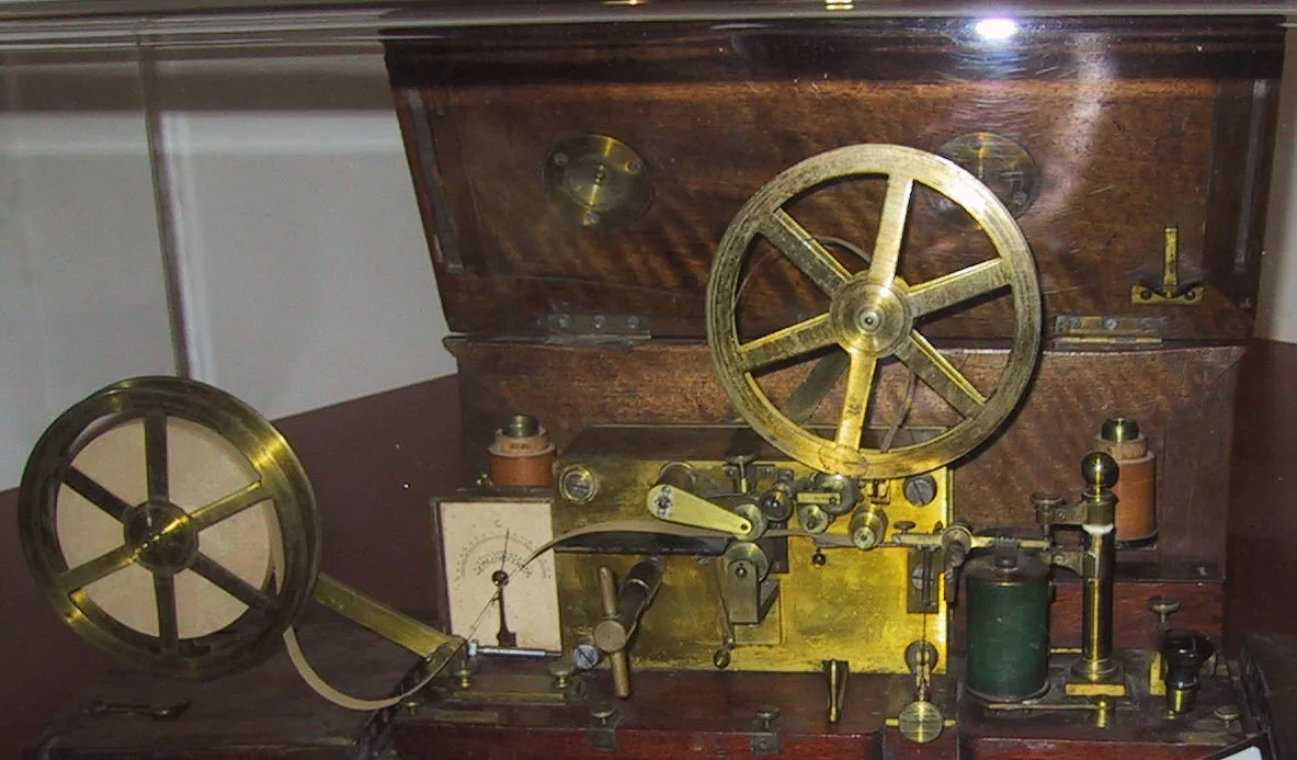 Early Morse telegraph apparatus on a wooden base with brass mechanism: the 1837 prototype with the recording mechanism that marks a paper tape