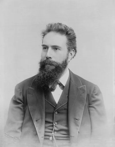 A portrait photograph of Wilhelm Röntgen: a bearded man in a dark suit with a serious gaze