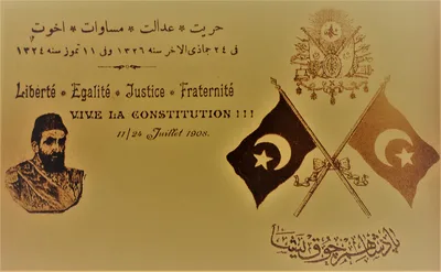 An Ottoman postcard celebrating the 1908 revolution: flags and period figures around four slogans