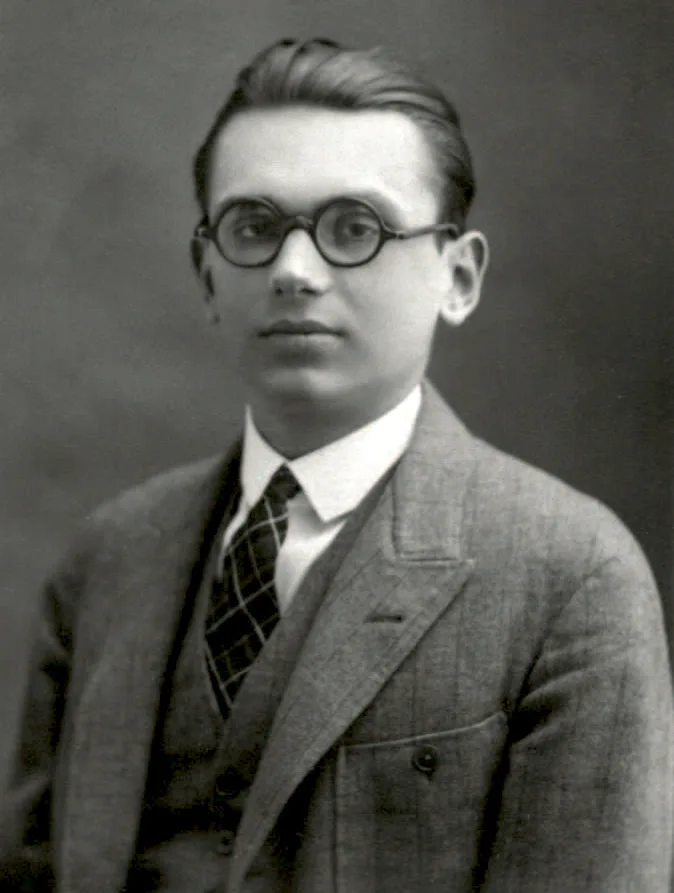 A black-and-white portrait of a young Kurt Gödel: fine features, round glasses, a dark suit and bow tie; looking directly at the camera