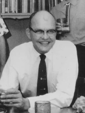 Black-and-white mid-career portrait of Jack Kilby: a serious-looking engineer in a suit and glasses