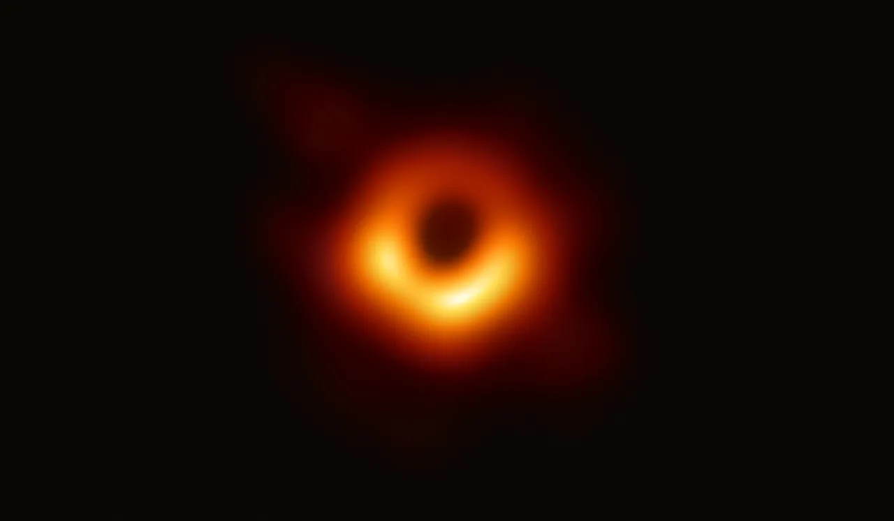A bright orange-gold ring with a dark black region at its centre: the Event Horizon Telescope's image of the supermassive black hole at the centre of M87