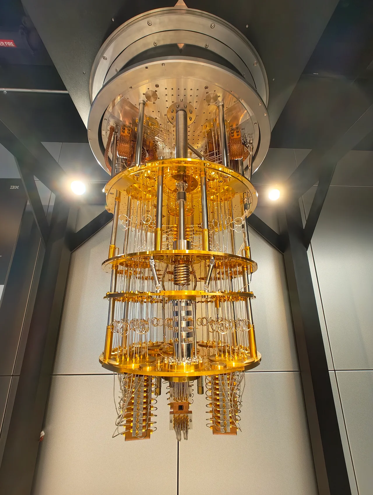 IBM Quantum System One: a gold-coloured cylindrical quantum processor unit suspended inside a glass cube