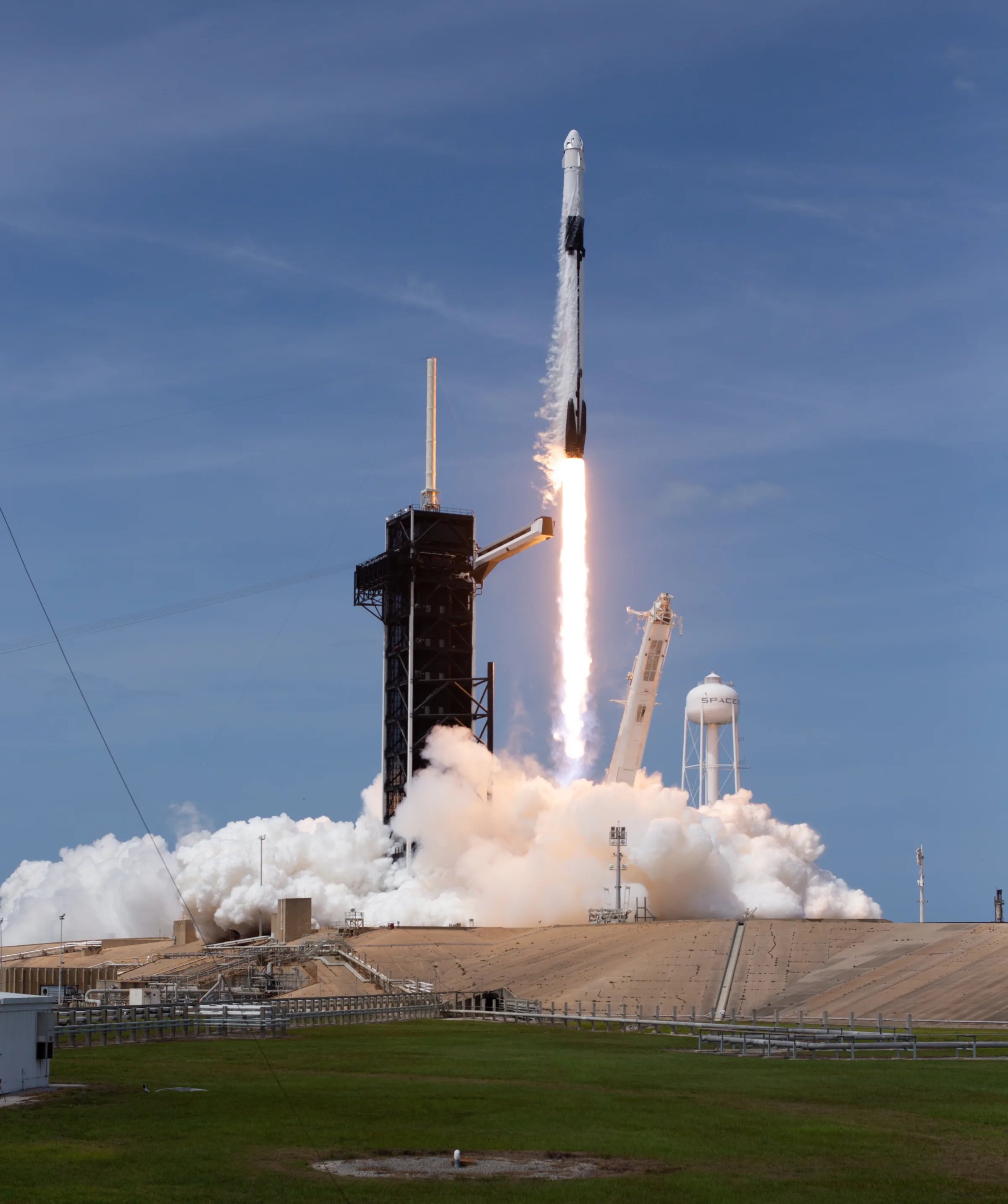 A Falcon 9 rocket lifting off from the Kennedy Space Center, with a column of flame and rising smoke