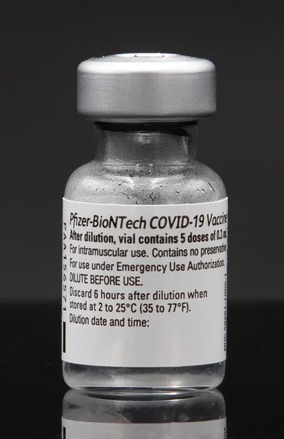 Close-up of a labelled glass vial of the BioNTech-Pfizer COVID-19 vaccine