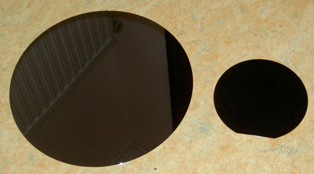A silicon disc covered with hundreds of rectangular chips, reflecting light in rainbow colours