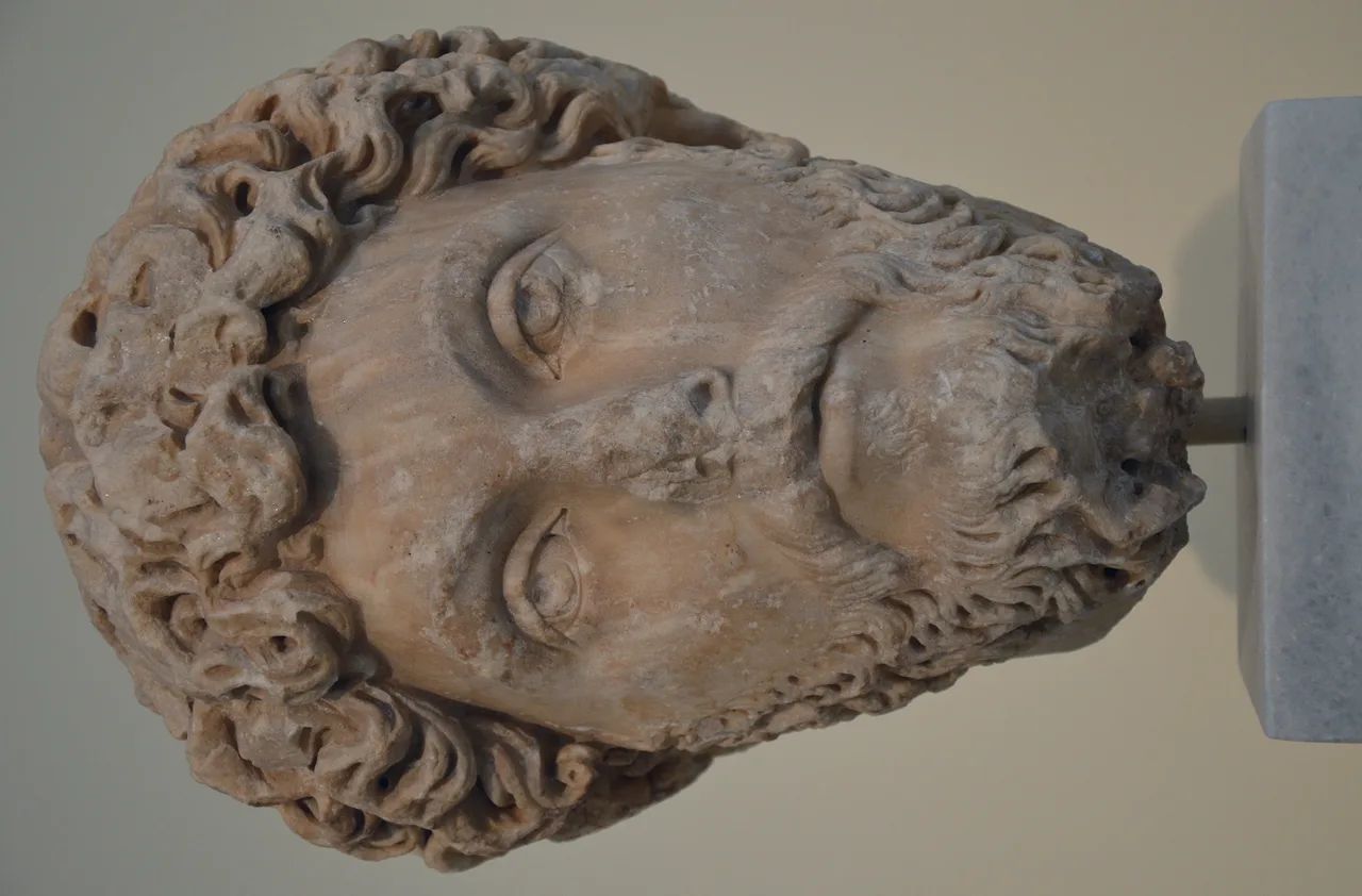Marble portrait head of Marcus Aurelius — curly hair, full beard, weary expression; found in Athens, now in the National Archaeological Museum of Athens