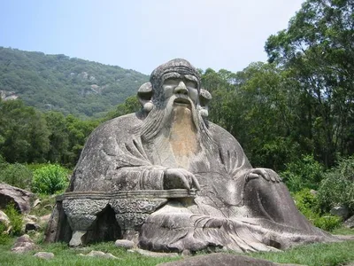 Monumental stone statue of Lao Tzu on Mount Qingyuan in Fujian, China, depicting him as a bearded, smiling old sage
