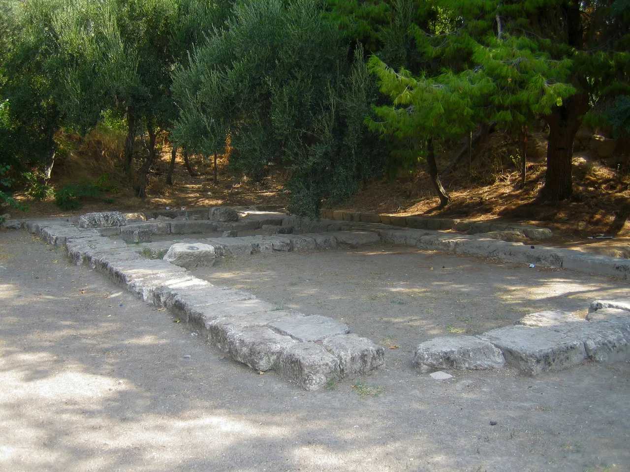The ancient stone ruins of Plato's Academy archaeological site in Athens surrounded by trees