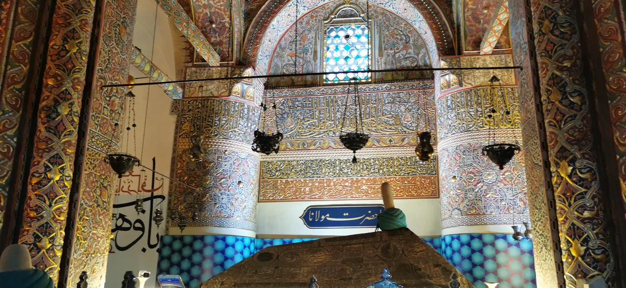 Konya'daki Mevlana Müzesi'nin firuze çinilerle kaplı yivli yeşil kubbesi ve bitişiğindeki minare, açık mavi gökyüzü altında