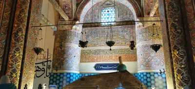 Konya'daki Mevlana Müzesi'nin firuze çinilerle kaplı yivli yeşil kubbesi ve bitişiğindeki minare, açık mavi gökyüzü altında