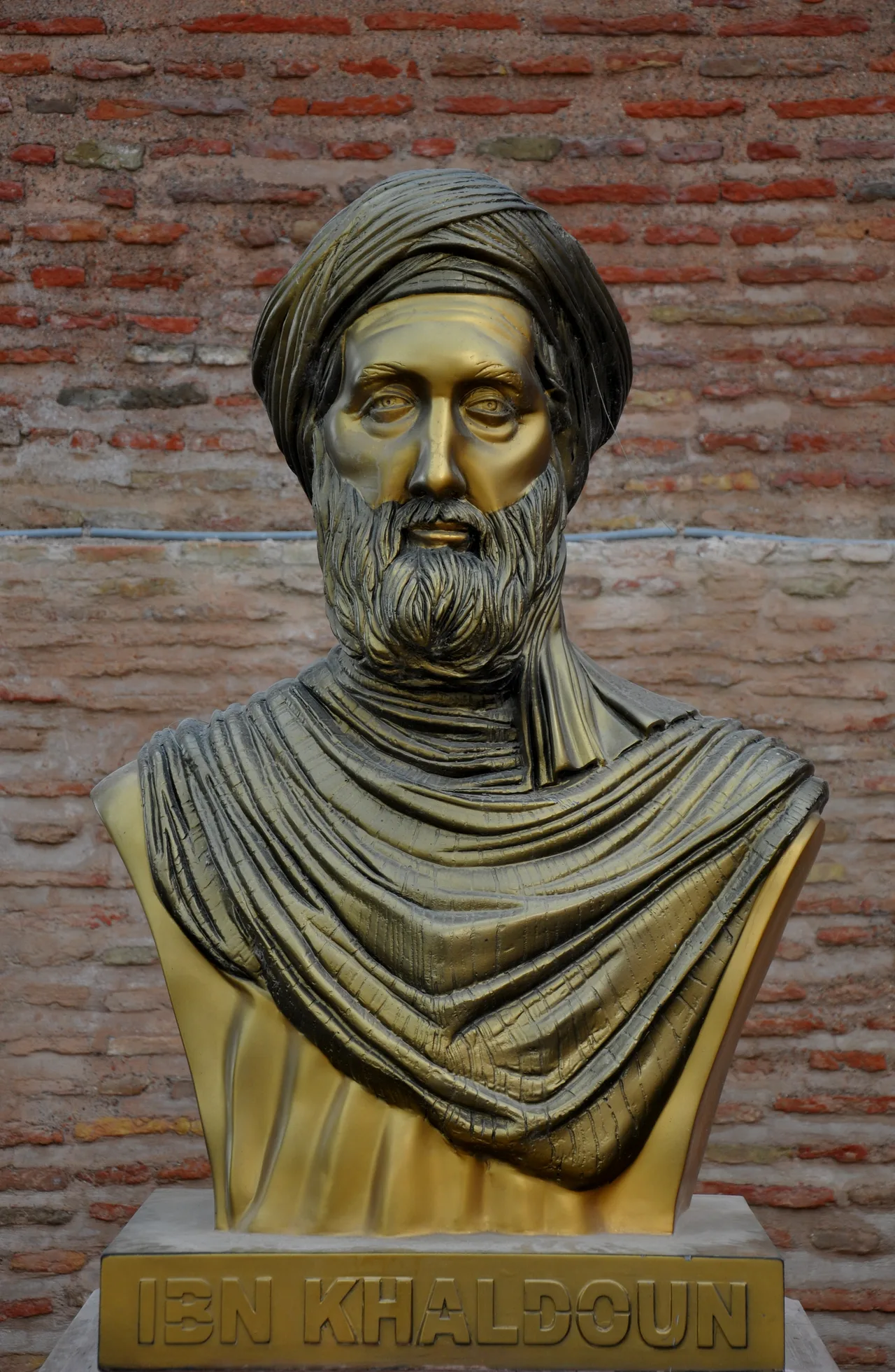 Bronze bust of Ibn Khaldun in the Casbah of Bejaia, Algeria, depicting him as a bearded, turbaned scholar